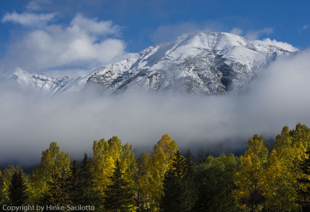 Snow covered peaks near Canmore, Canadian Rockies, fog rising.