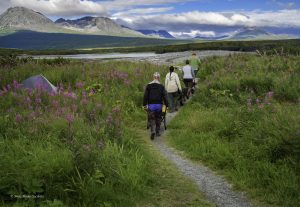 Retrieving raw water using wheel barrels to haul containers.